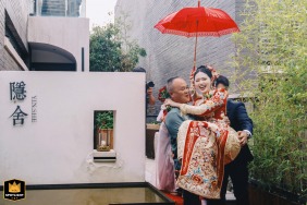 In Kaifeng, Henan, China, the bride's older brother tenderly carries his newly married sister as she departs from the home.